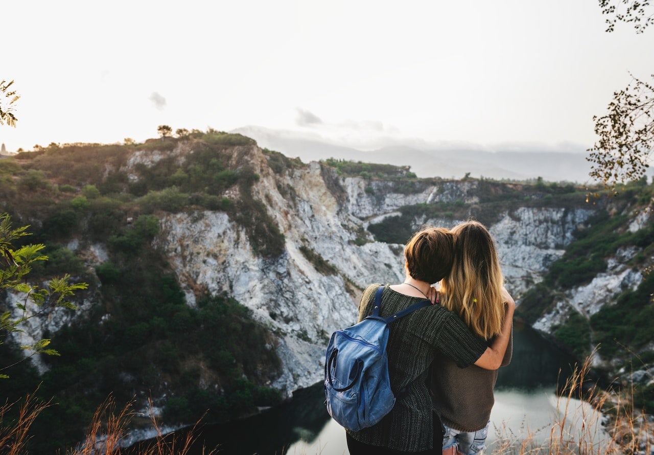 two women hugging and looking at a view