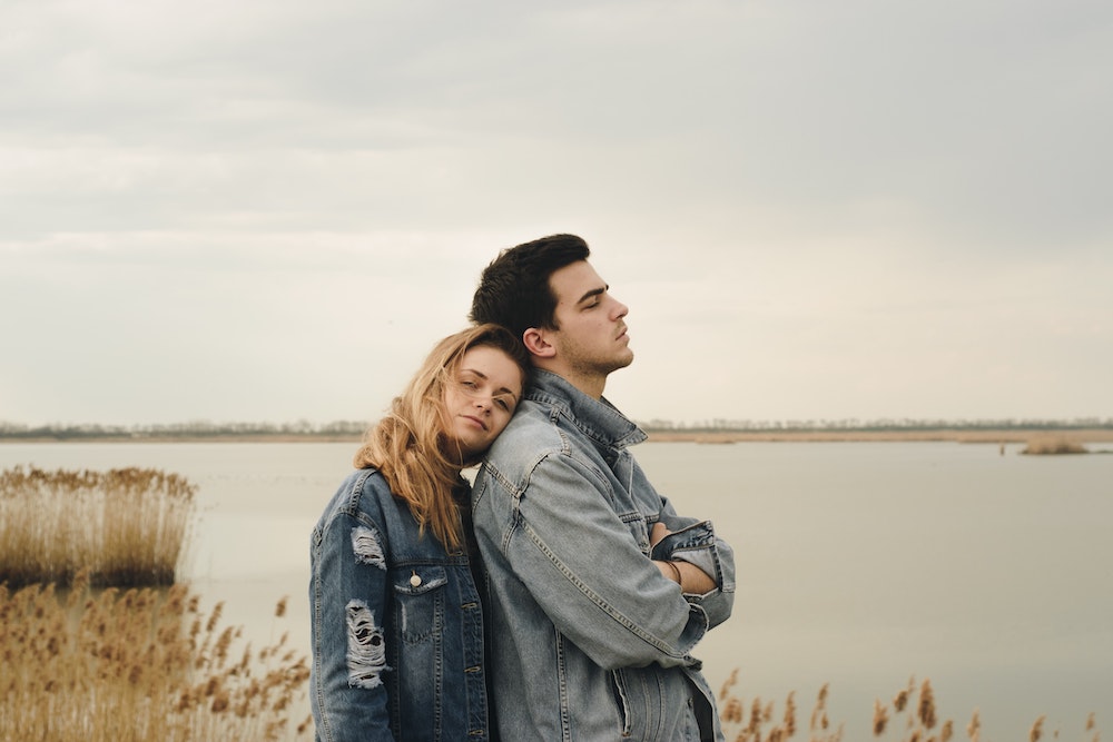 couple cuddling by lake